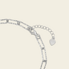 Close-up of a silver chain necklace showing a lobster clasp, extension chain, and a heart-shaped tag engraved with 'LOVE'.