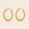 A pair of gold hoop earrings with a twisted rope design, shown on a light beige background. The inside of the hoops shows a '925' sterling silver hallmark.