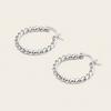A pair of silver twisted rope hoop earrings with fishhook backings, displayed on a light beige background.