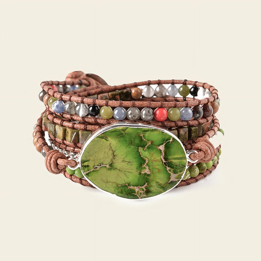 Multistrand bracelet with a green stone centerpiece on a beige background