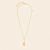 A delicate gold chain necklace with a polished teardrop pendant, displayed against a solid light beige background.