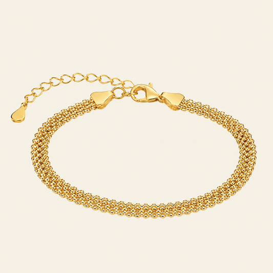 Gold bracelet on a beige background