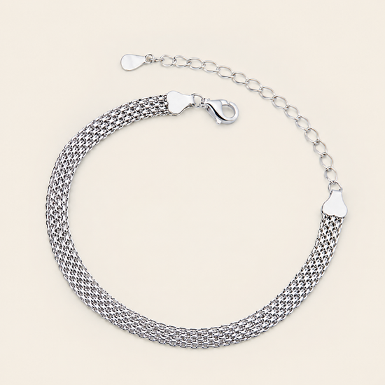 A silver mesh chain bracelet with a lobster clasp and extender chain, displayed on a light beige background.