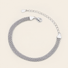 A silver mesh chain bracelet with a lobster clasp and extender chain, displayed on a light beige background.