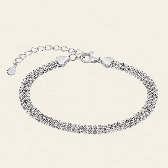 A silver multi-strand mesh chain bracelet with a lobster clasp and extender chain, displayed on a light cream background.