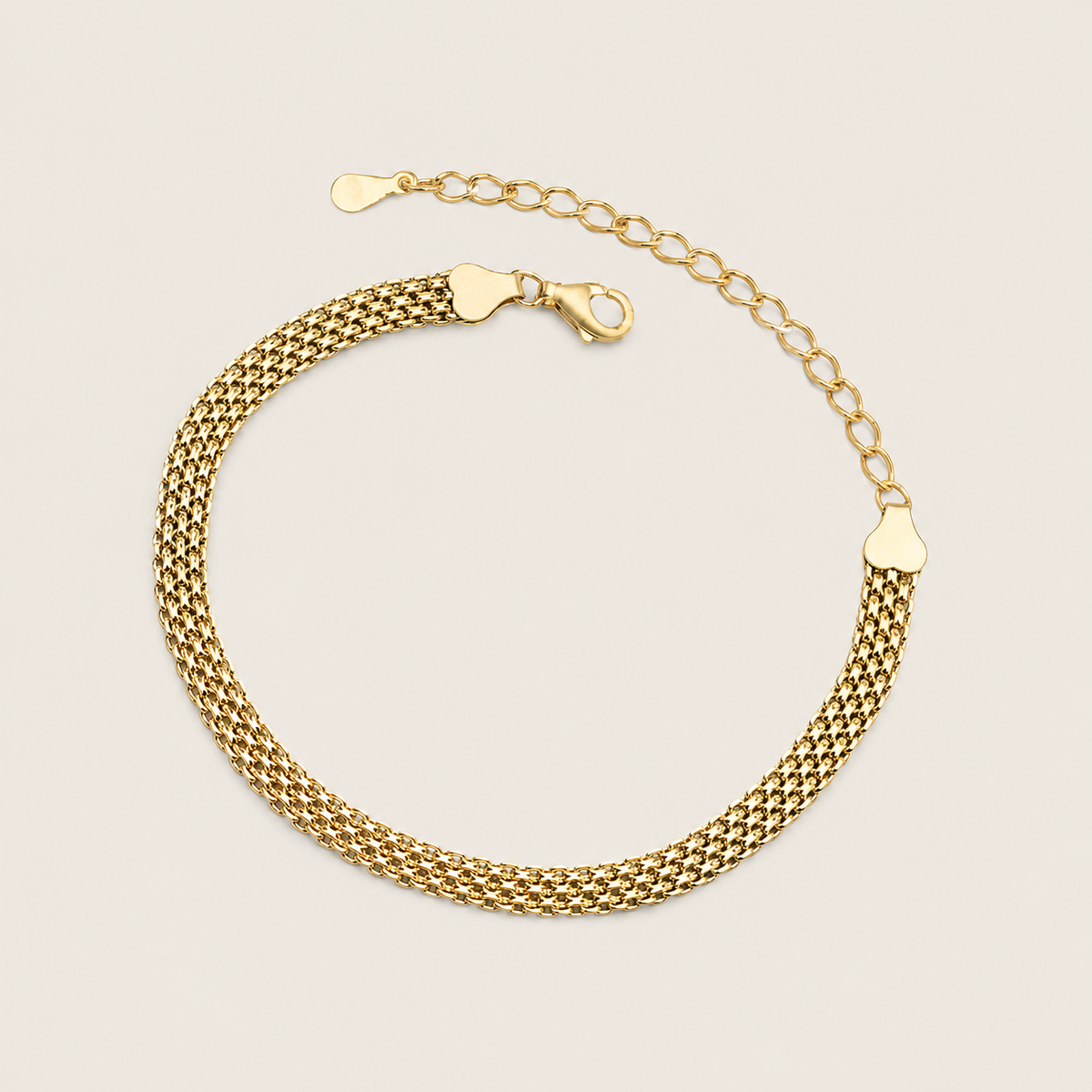 A gold chain bracelet with a textured mesh-like woven band, a lobster clasp, and an adjustable extender chain with heart-shaped links, shown on a light beige background.