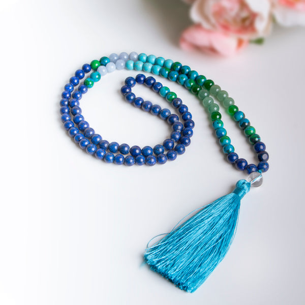 Handmade necklace with blue, green, and turquoise beads and a silky bright blue tassel