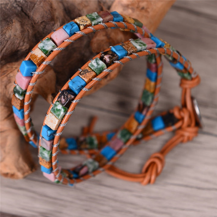 Handmade adjustable 2-layer wrap bracelet with a colorful blend of natural cubic stones in turquoise, pink, green, brown, and white shades. Crafted with durable leather and silver stitching, this boho-inspired piece offers a comfortable fit and lasting style, ideal for layering or wearing alone as a vibrant accessory.