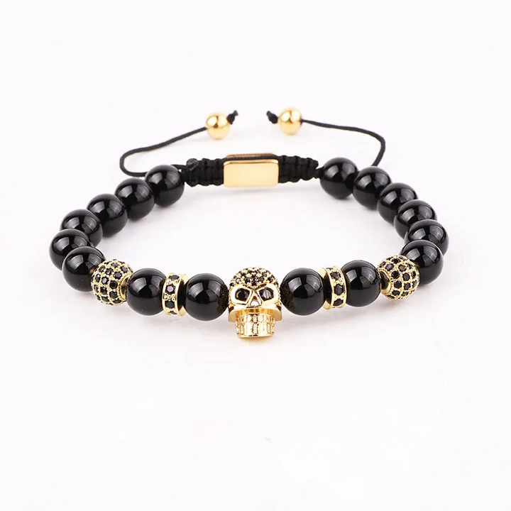 Handmade adjustable bracelet featuring black onyx beads and a gold zircon skull charm, a bold gothic-inspired accessory for men and women.