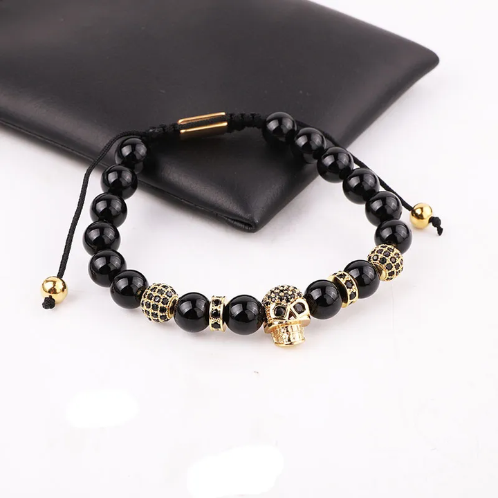 Handmade adjustable bracelet with black onyx beads and a gold zircon skull charm, perfect for gothic and edgy fashion styles.