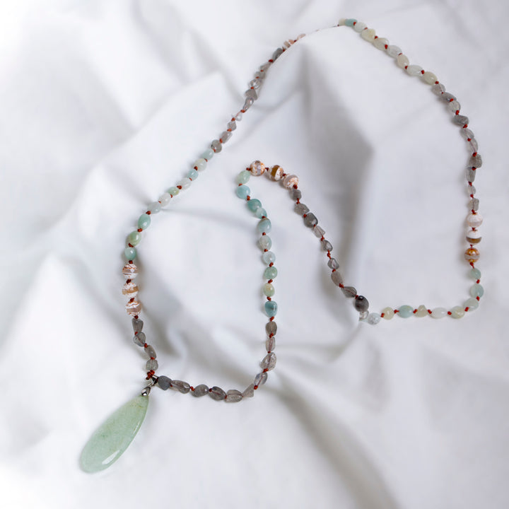 Handmade beaded necklace with a large green teardrop pendant, featuring mixed natural stones in soft earthy tones, perfect for a boho-inspired layered look.