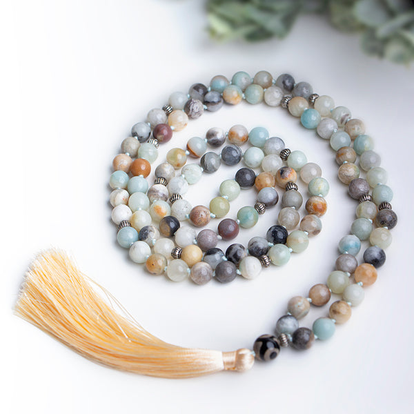 Close-up of handmade necklace featuring round natural Amazonite beads in earthy tones with silver spacers and a peach tassel pendant, ideal for a boho-inspired look.