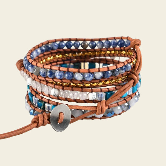 Handmade adjustable bracelet with Sodalite beads, gold accents, and a leather band, offering a stylish boho design perfect for any occasion.