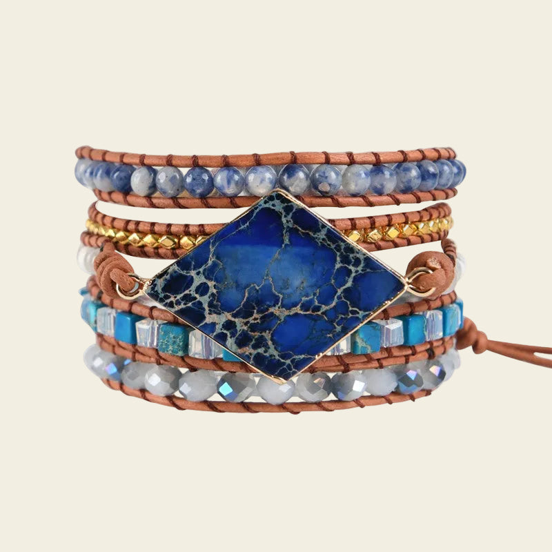 Handmade adjustable bracelet featuring a large Lapis Lazuli gemstone, blue and golden beads, and a leather band, perfect for boho-style enthusiasts.