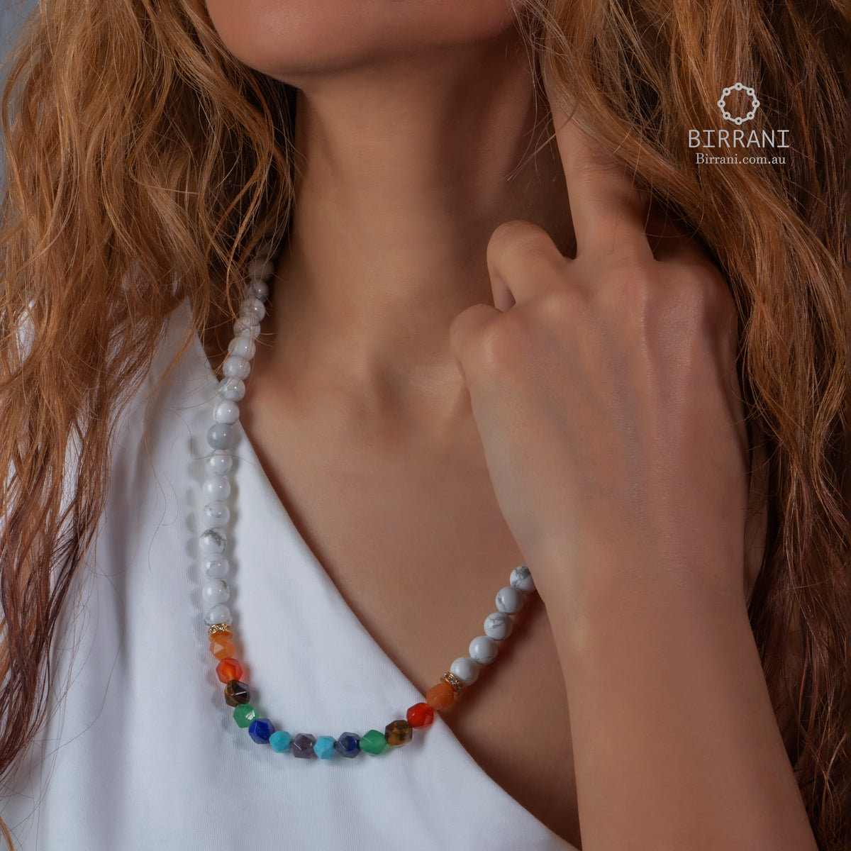Close-up of a model wearing a handmade 7 Chakra natural stones necklace with vibrant colored beads.