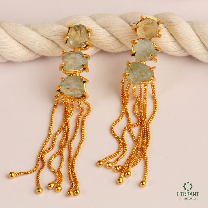 Handmade gold-plated earrings featuring three aquamarine stones with long tassels, offering a luxurious and stylish touch for any occasion.