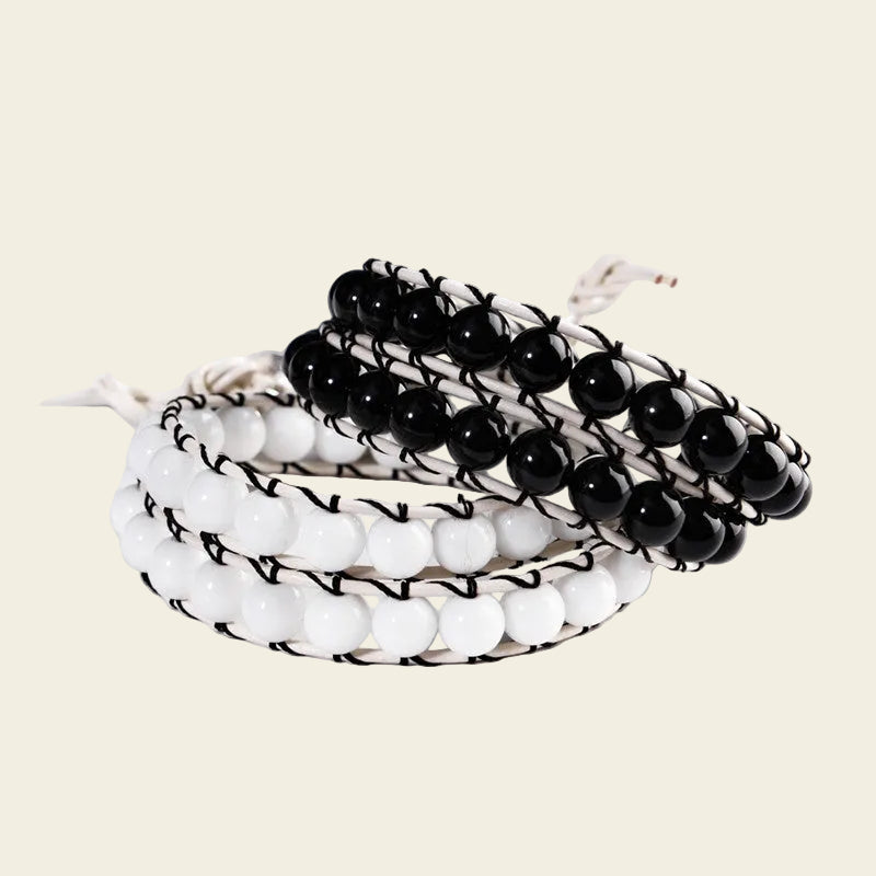 Handmade adjustable bracelet featuring black and white Agate beads, woven with black cord, offering a modern and stylish accessory with a monochrome color scheme.