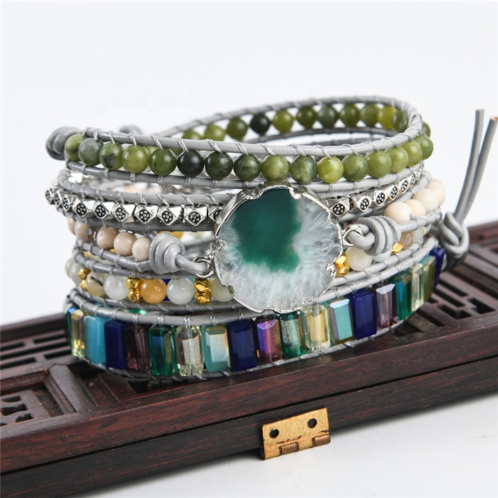 Handmade adjustable bracelet with natural moss agate slice, green beads, metallic accents, and colourful stones in a 5-layer design, ideal for boho jewellery enthusiasts.