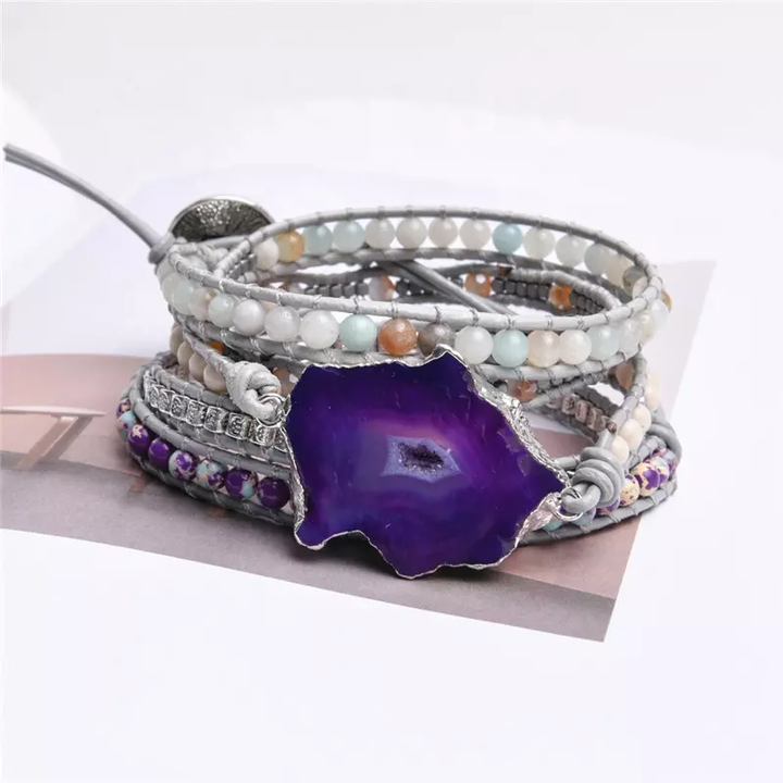 Handmade wrap bracelet featuring a large amethyst geode centerpiece, surrounded by natural stones and silver-plated accents, adjustable fit for casual or boho styles.