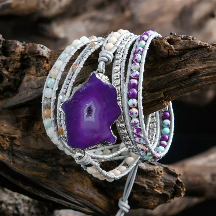 Handmade wrap bracelet featuring a bold amethyst geode centerpiece, adorned with natural stones and silver-plated accents, adjustable for a boho-chic style.