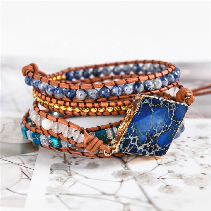 Handmade boho bracelet with a Lapis Lazuli centerpiece, Sodalite, turquoise, and gold beads, on a leather strap, perfect for a boho-style gift.
