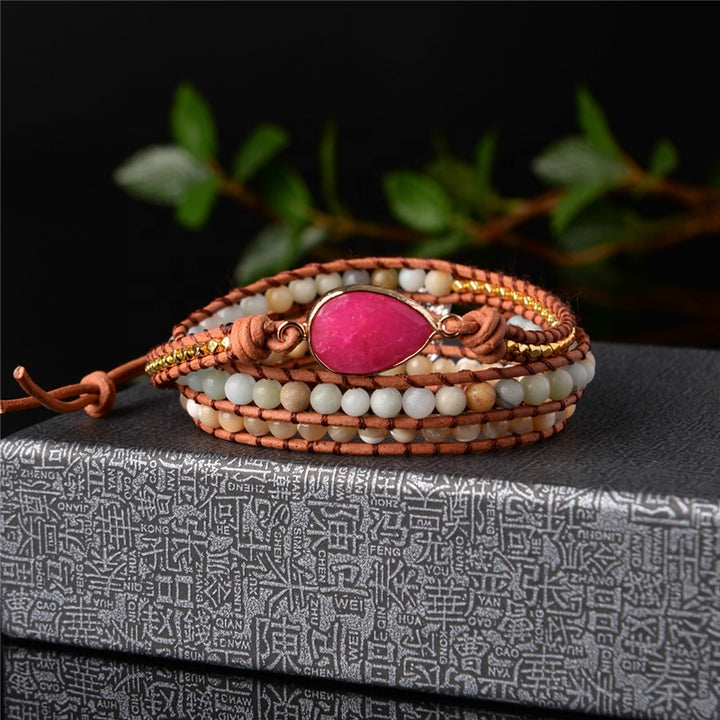 Handmade wrap bracelet featuring Rhodochrosite stone, beige and white beads, and gold accents, perfect for adding a boho touch to any outfit.