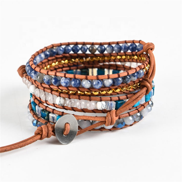 Handmade adjustable bracelet with Sodalite beads, gold accents, and a leather band, offering a stylish boho design perfect for any occasion.