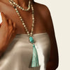 Handmade yoga necklace featuring a turquoise pendant with a soft tassel and natural stone beads, perfect for meditation or boho-style outfits.