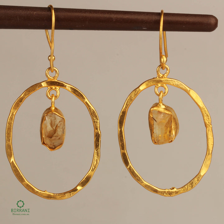 Handmade gold-plated earrings featuring natural citrine stones in an elegant circular design, perfect for adding a touch of sophistication to any outfit.