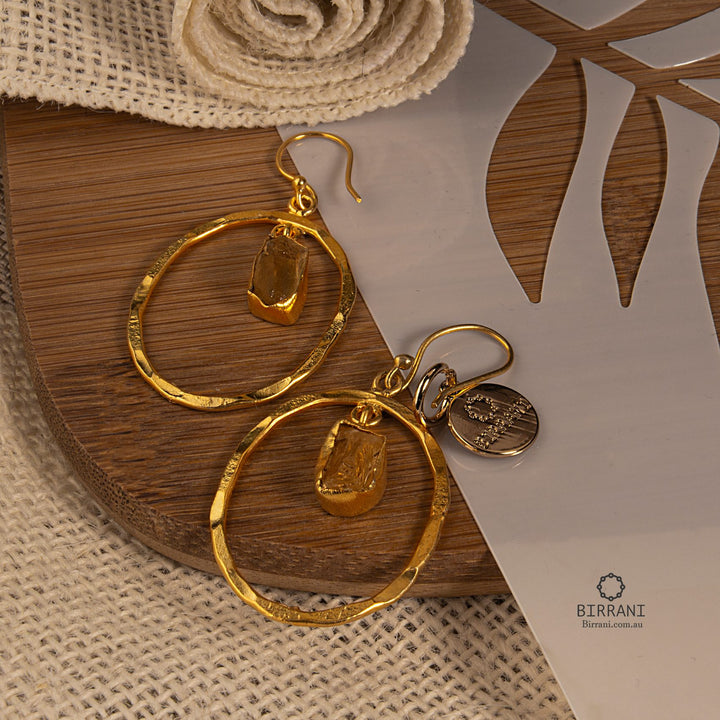 Handmade gold-plated hoop earrings featuring natural citrine stones, adding a touch of elegance and style to any occasion.