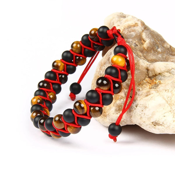 Handmade bracelet featuring black onyx and tiger eye stone beads with adjustable red cord detailing, designed for a personalized fit.
