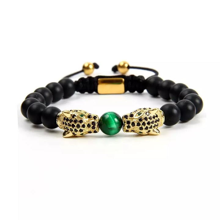 A handcrafted adjustable bracelet by Birrani showcases matte black agate beads and a striking green malachite centre, accented by two detailed gold leopard head charms encrusted with CZ stones. The bracelet combines strength, confidence, and bold design, strung on a durable cord with gold accents. This unique natural stone accessory is perfect for gifting or adding a touch of statement style to any look.

