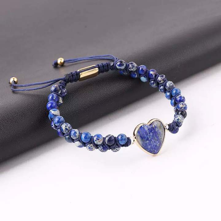 Handmade adjustable bracelet featuring blue Lapis Lazuli beads and a heart-shaped stone centerpiece, set with gold-tone accents.