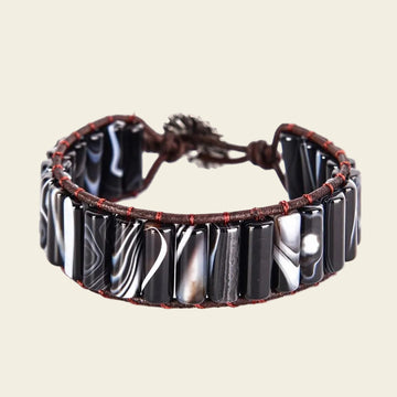 Adjustable bracelet made with smooth onyx tubes and leather cord, offering a modern and stylish natural stone design. Perfect for casual or everyday wear.