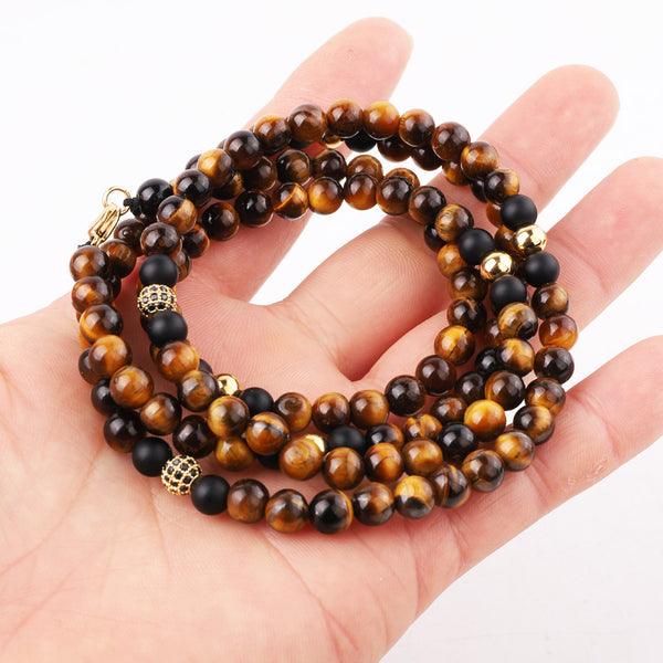 Handmade multi-layered necklace with tiger eye and matte onyx beads, featuring gold accents, designed for a chic and bold style.