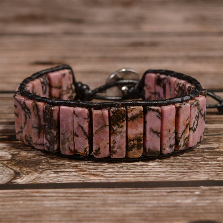 Adjustable bracelet featuring Rhodonite natural stone tubes with earthy pink and black veins, secured with a durable leather cord and a silver button closure.