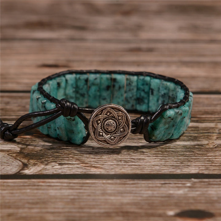 Handmade adjustable Serpentine bracelet with turquoise stone tubes, featuring a silver metal clasp with intricate design, and leather cord.