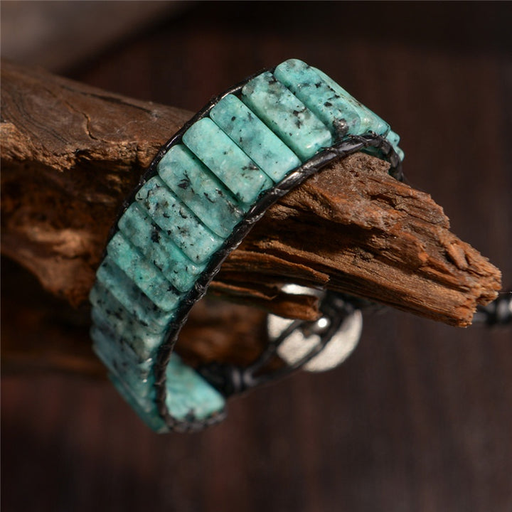 Adjustable leather wrap bracelet featuring natural turquoise-colored Serpentine stone tube beads, secured with a stylish clasp, perfect for everyday wear.